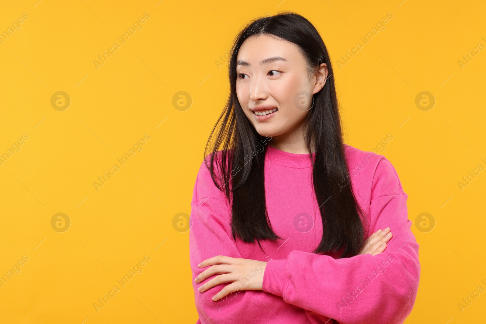 Photo of Portrait of smiling woman on orange background. Space for text