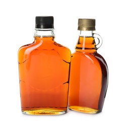 Bottles of tasty maple syrup on white background