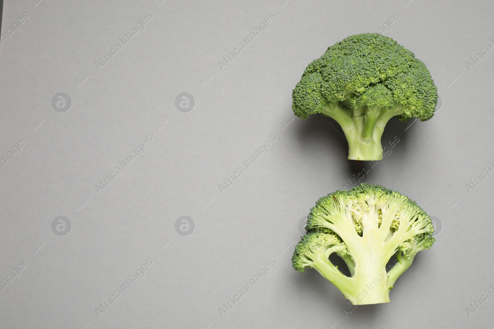 Photo of Fresh tasty broccoli on grey background, flat lay. Space for text