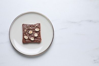 Photo of Toast with tasty nut butter and nuts on white marble table, top view. Space for text