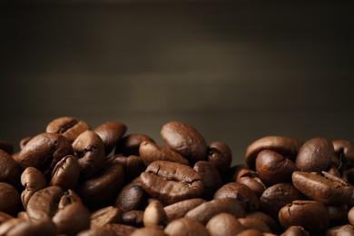 Photo of Heap of aromatic roasted coffee beans, closeup