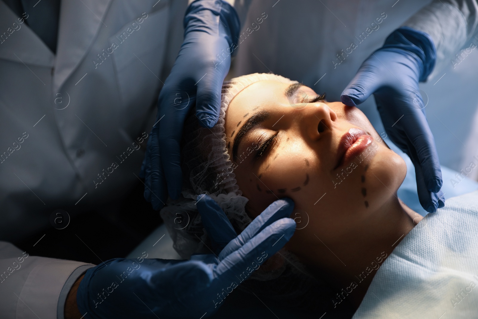 Photo of Doctor and nurse preparing female patient for cosmetic surgery in clinic