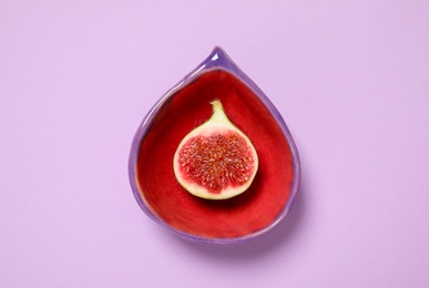 Photo of Ripe fig fruit in bowl on pink background, top view