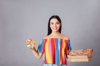 Photo of Beautiful woman with pizza on grey background