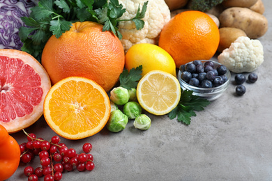 Photo of Different products rich in vitamin C on light grey table