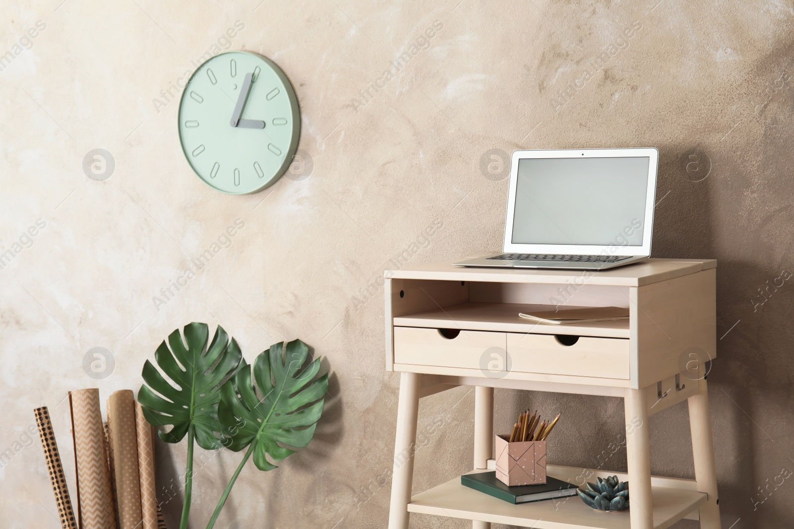 Photo of High wooden table with laptop as stand up workplace in modern interior