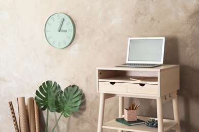 High wooden table with laptop as stand up workplace in modern interior