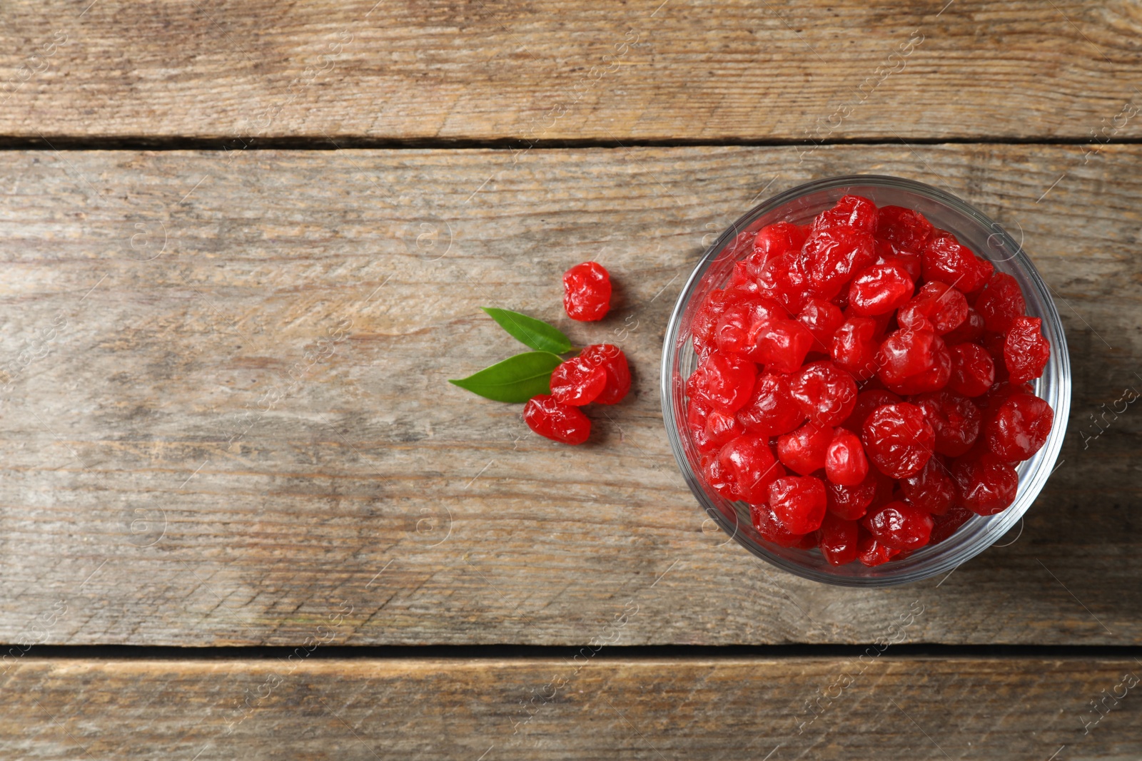 Photo of Bowl of sweet cherries on wooden background, top view with space for text. Dried fruit as healthy snack