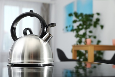 Modern kettle with whistle on stove in kitchen, space for text