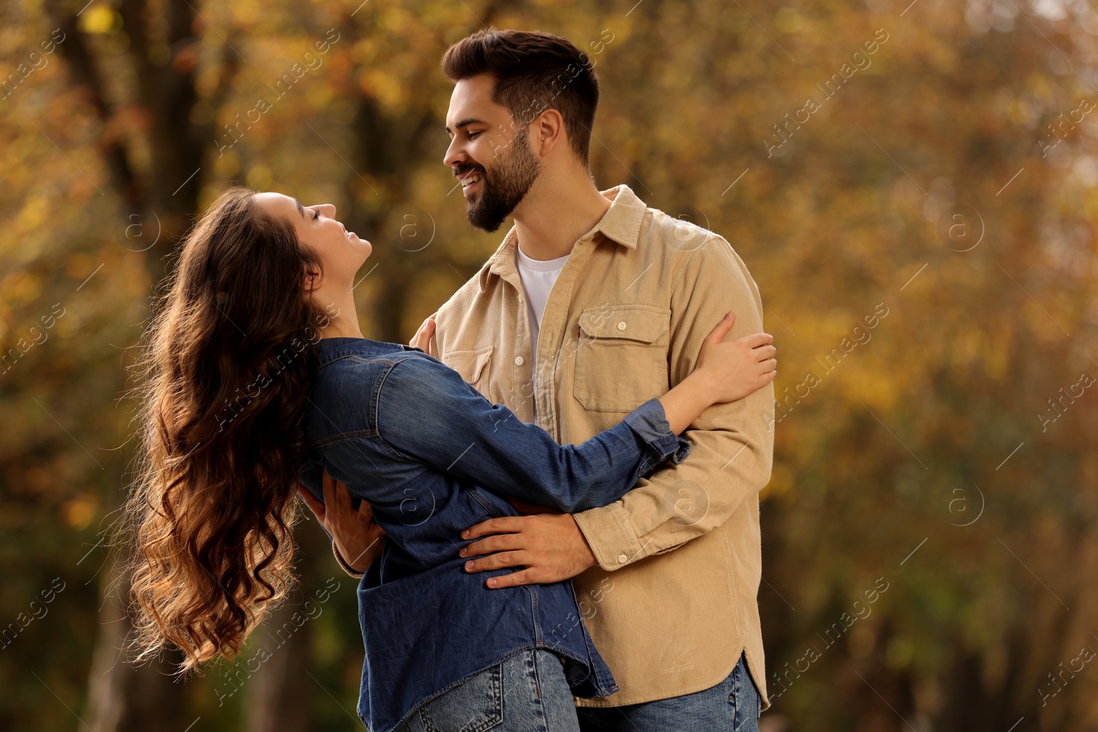 Photo of Beautiful couple spending time together in autumn park, space for text