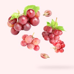 Image of Fresh grapes and leaves in air on light red background