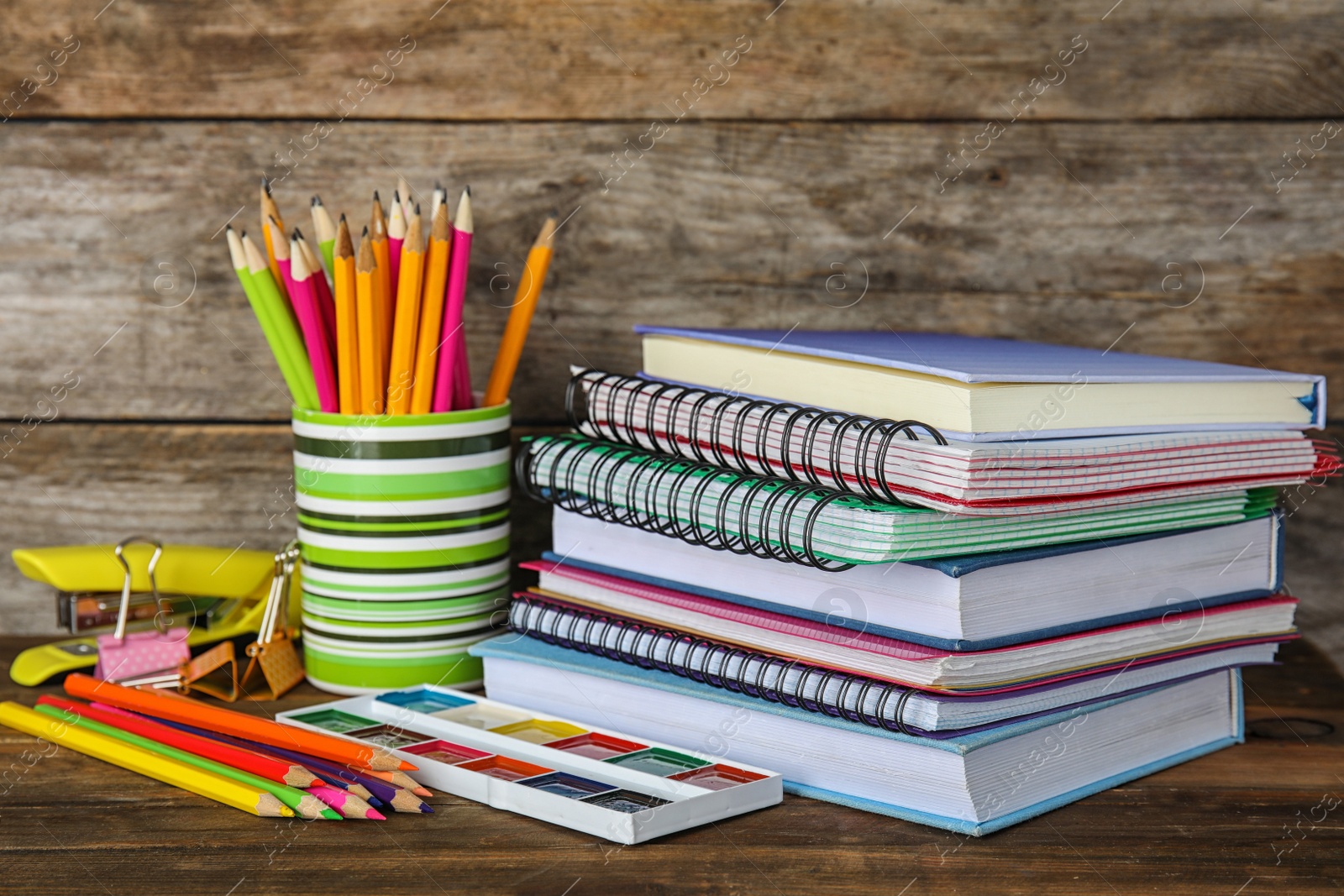 Photo of Different school stationery on table against wooden background