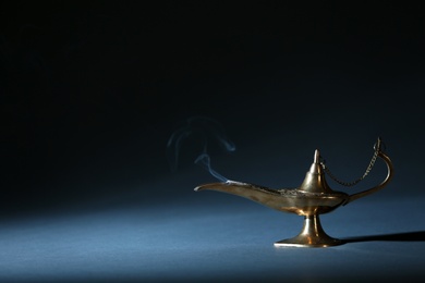 Aladdin lamp of wishes on table against dark background