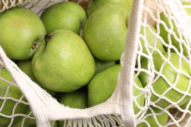 Fresh green apples in net bag, closeup