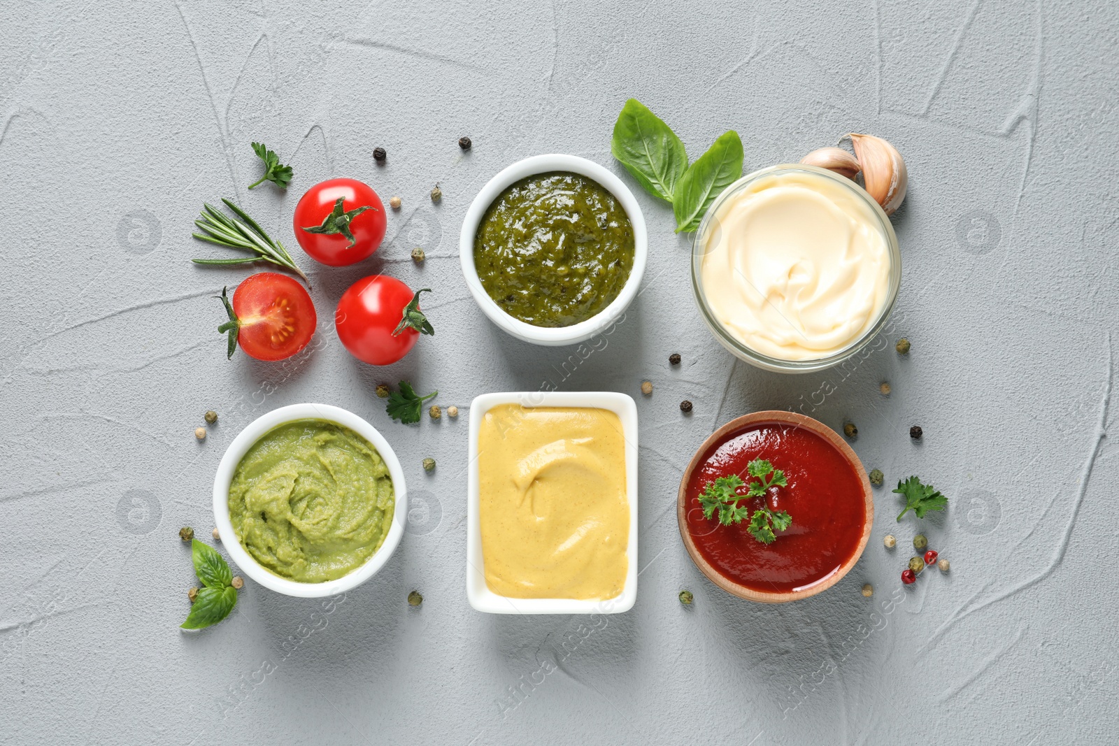 Photo of Flat lay composition with different sauces and ingredients on gray background