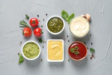 Flat lay composition with different sauces and ingredients on gray background