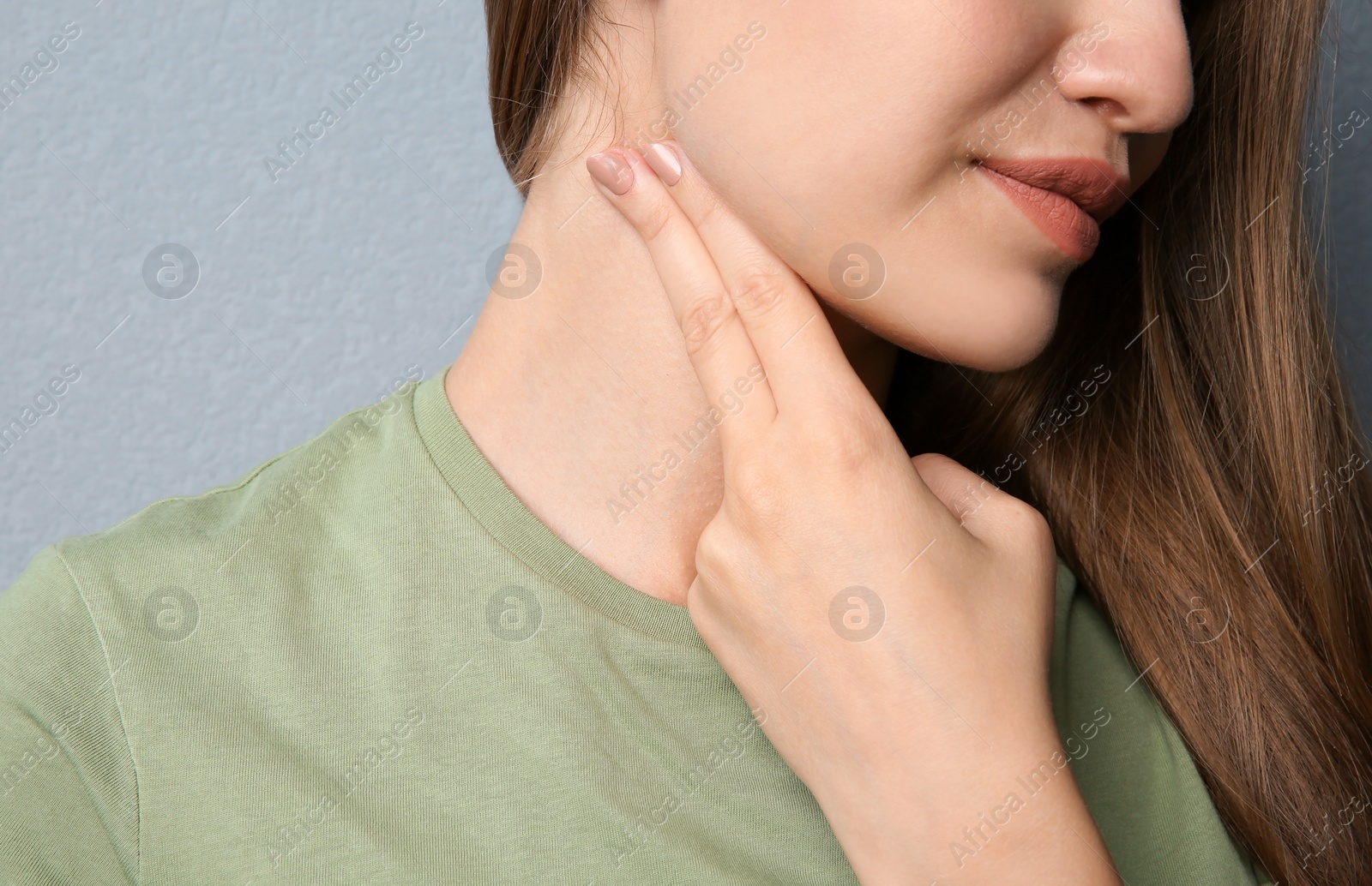 Photo of Young woman checking pulse on color background