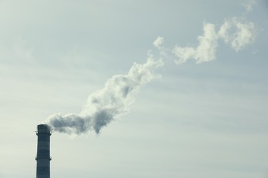 Photo of Polluting air with smoke from industrial chimney outdoors, space for text. CO2 emissions