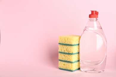 Photo of Cleaning product and sponges on pink background, space for text. Dish washing supplies
