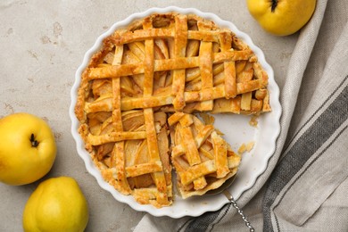 Photo of Tasty homemade quince pie with cake server and fresh fruits on light grey table, flat lay