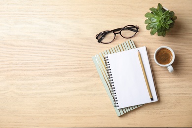 Photo of Flat lay composition with notebooks, coffee and space for text on wooden background