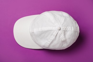 Photo of Baseball cap on purple background, top view. Mock up for design