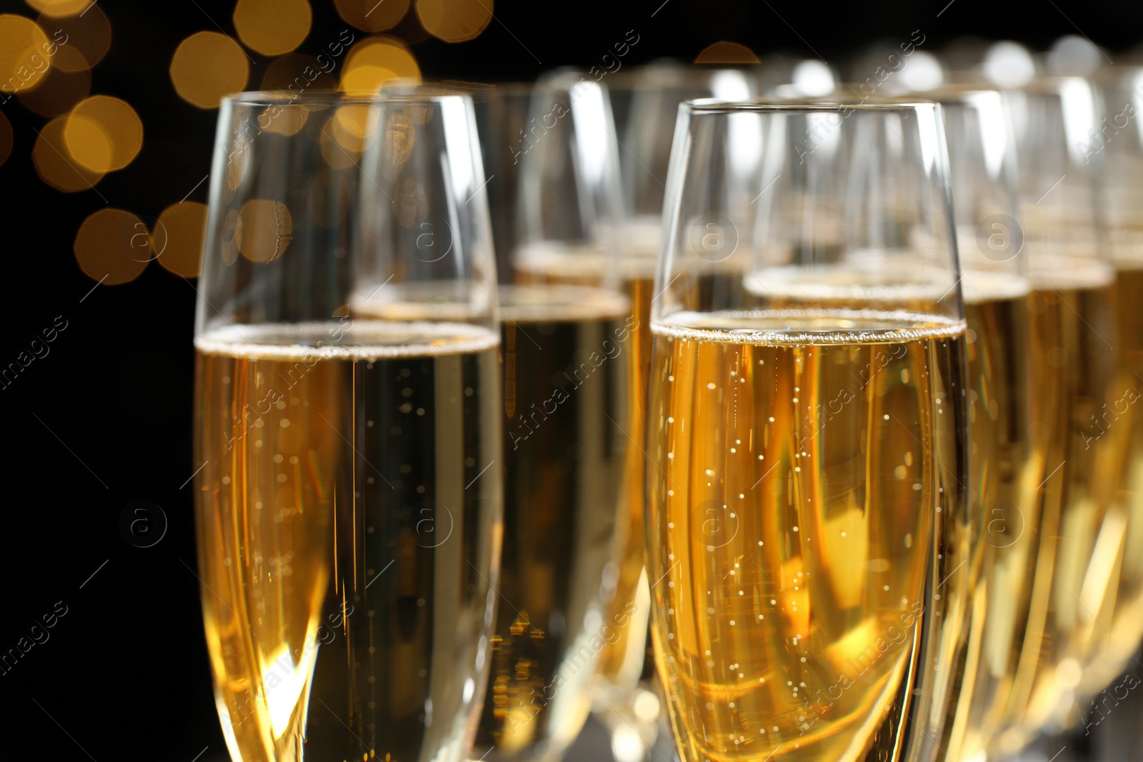 Photo of Many glasses of champagne on blurred background, closeup