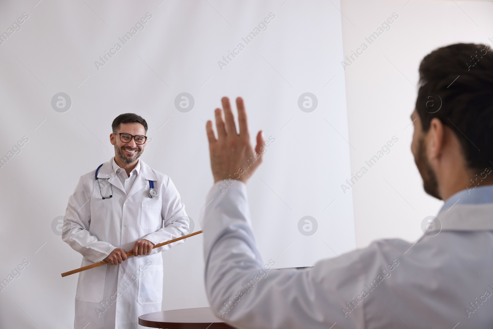 Photo of Doctor giving lecture in conference room with projection screen