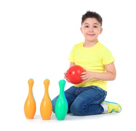 Photo of Playful little child with plastic bowling set on white background. Indoor entertainment