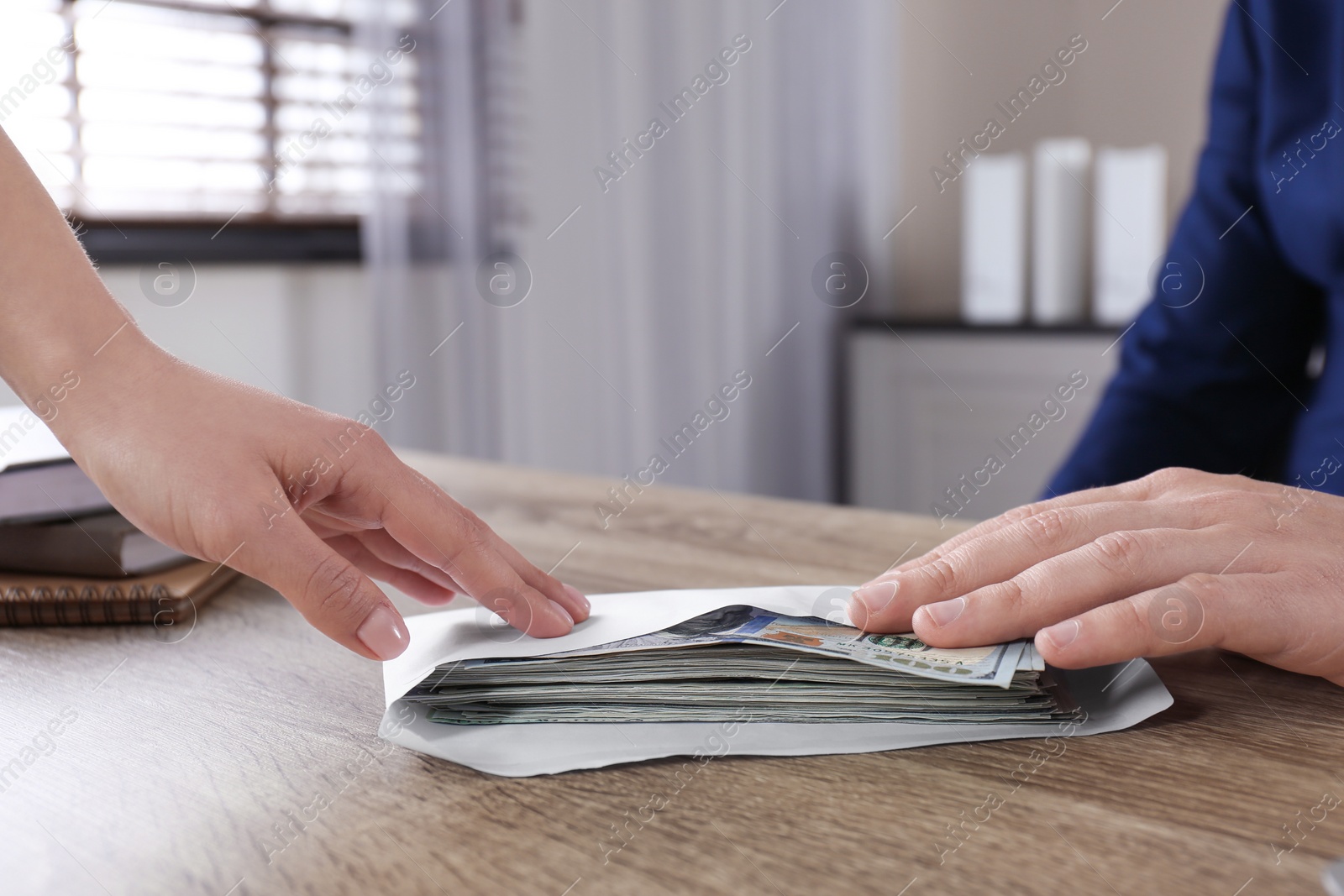 Photo of Woman giving bribe to man at table in office, closeup