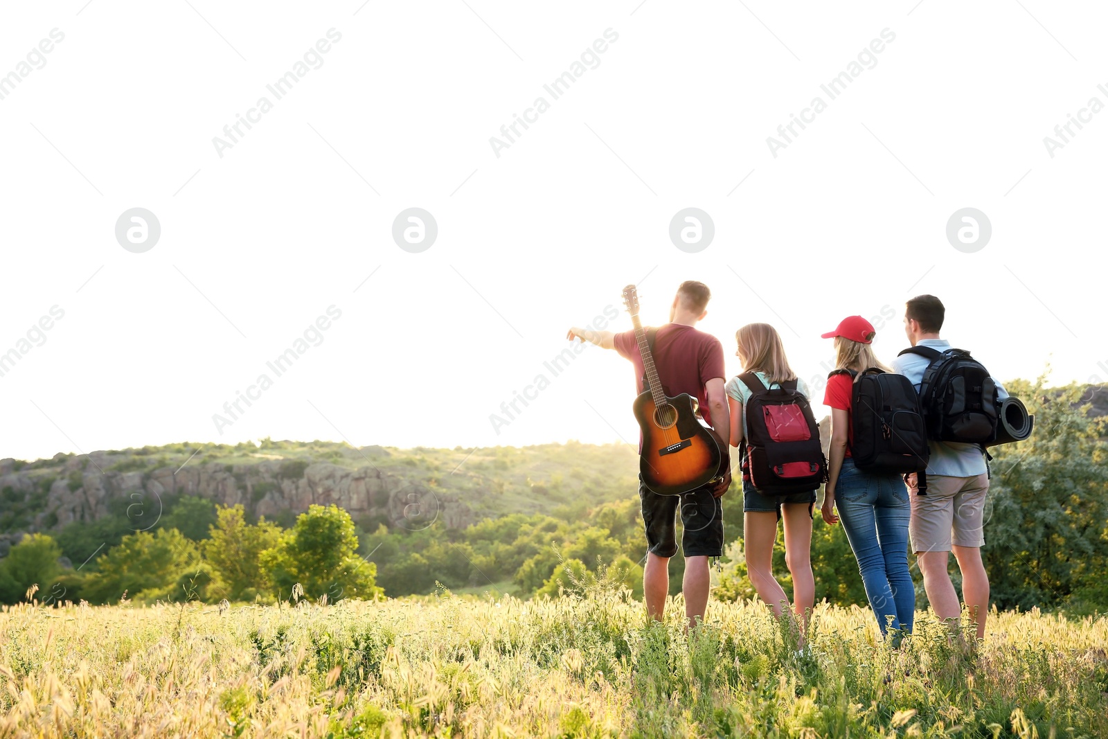 Photo of Group of young people with backpacks in wilderness. Camping season