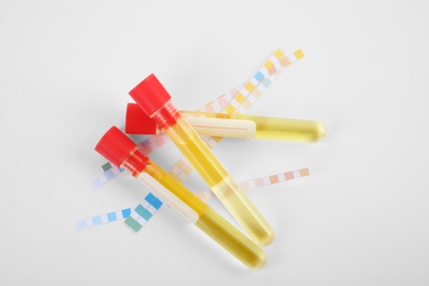 Photo of Test tubes with urine samples for analysis on white background, top view