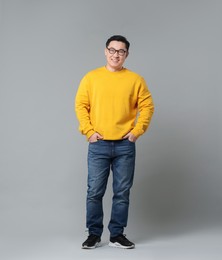 Full length portrait of happy man on grey background. Space for text