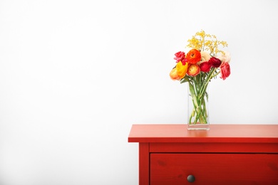 Photo of Vase with beautiful ranunculus flowers indoors