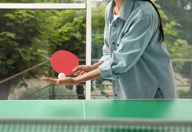 Photo of Woman playing ping pong indoors, closeup view