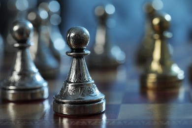Photo of Metal pawns on chess board, selective focus. Space for text