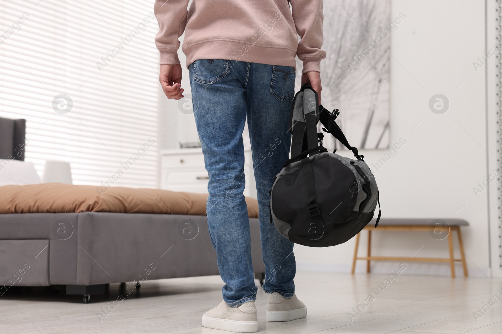 Photo of Guest with bag walking in hotel room, closeup