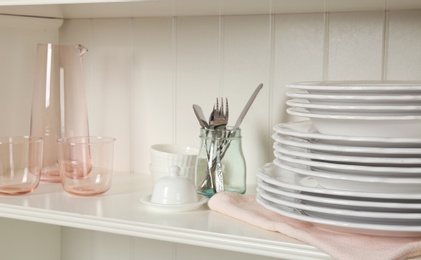 White shelving unit with set of dishware