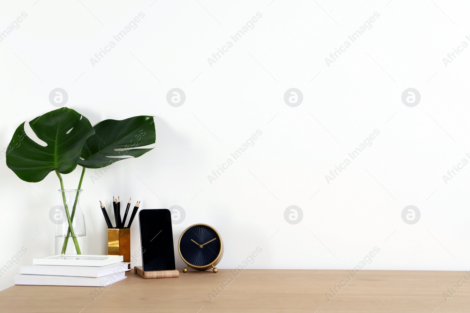 Photo of Comfortable workplace with wooden desk near white wall at home