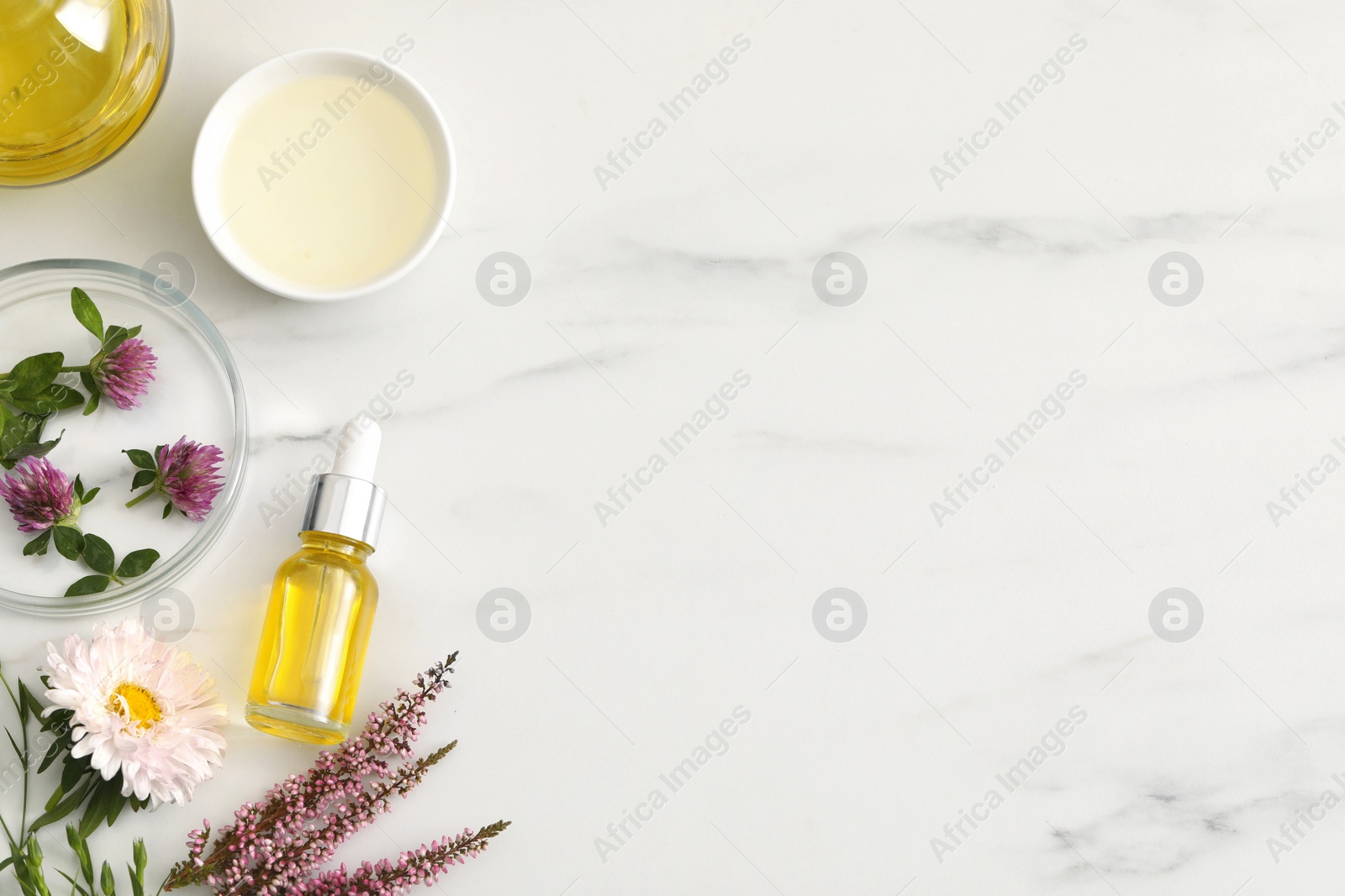 Photo of Flat lay composition with bottle of cosmetic oil on white marble table, space for text