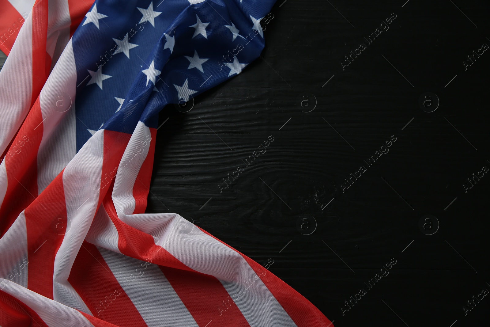 Photo of Flag of USA on black wooden table, top view. Space for text