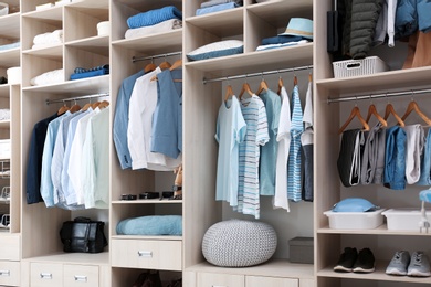 Stylish clothes, shoes and home stuff in large wardrobe closet