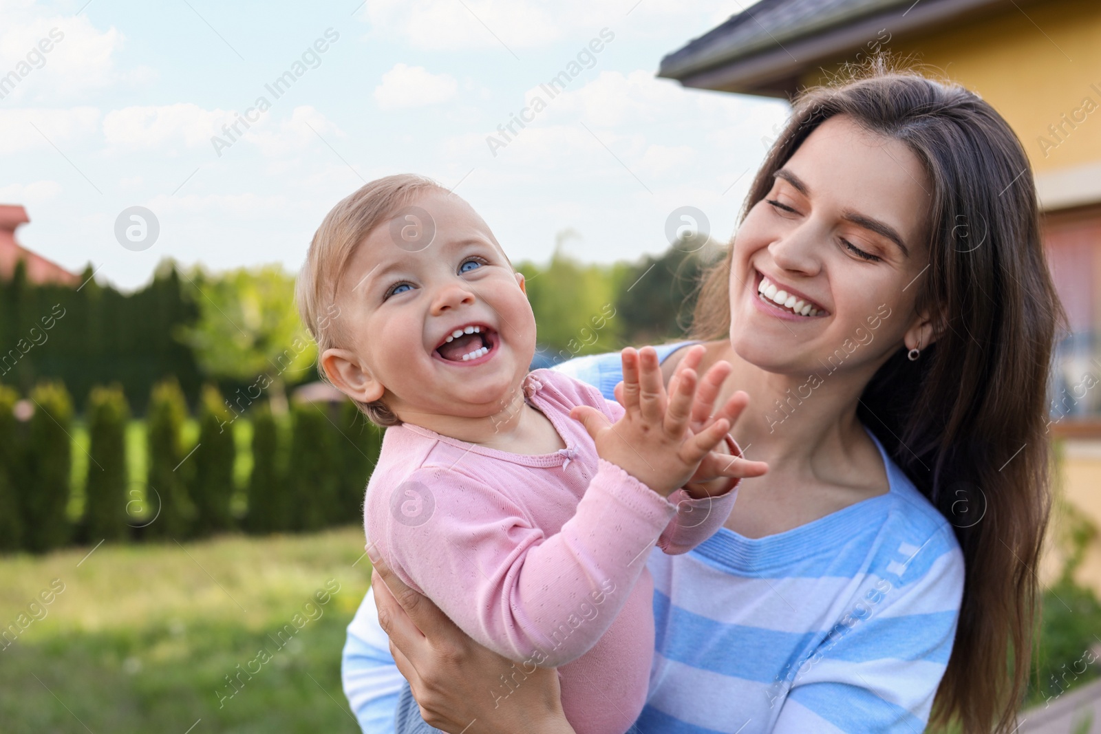 Photo of Happy mother with her cute baby at backyard on sunny day