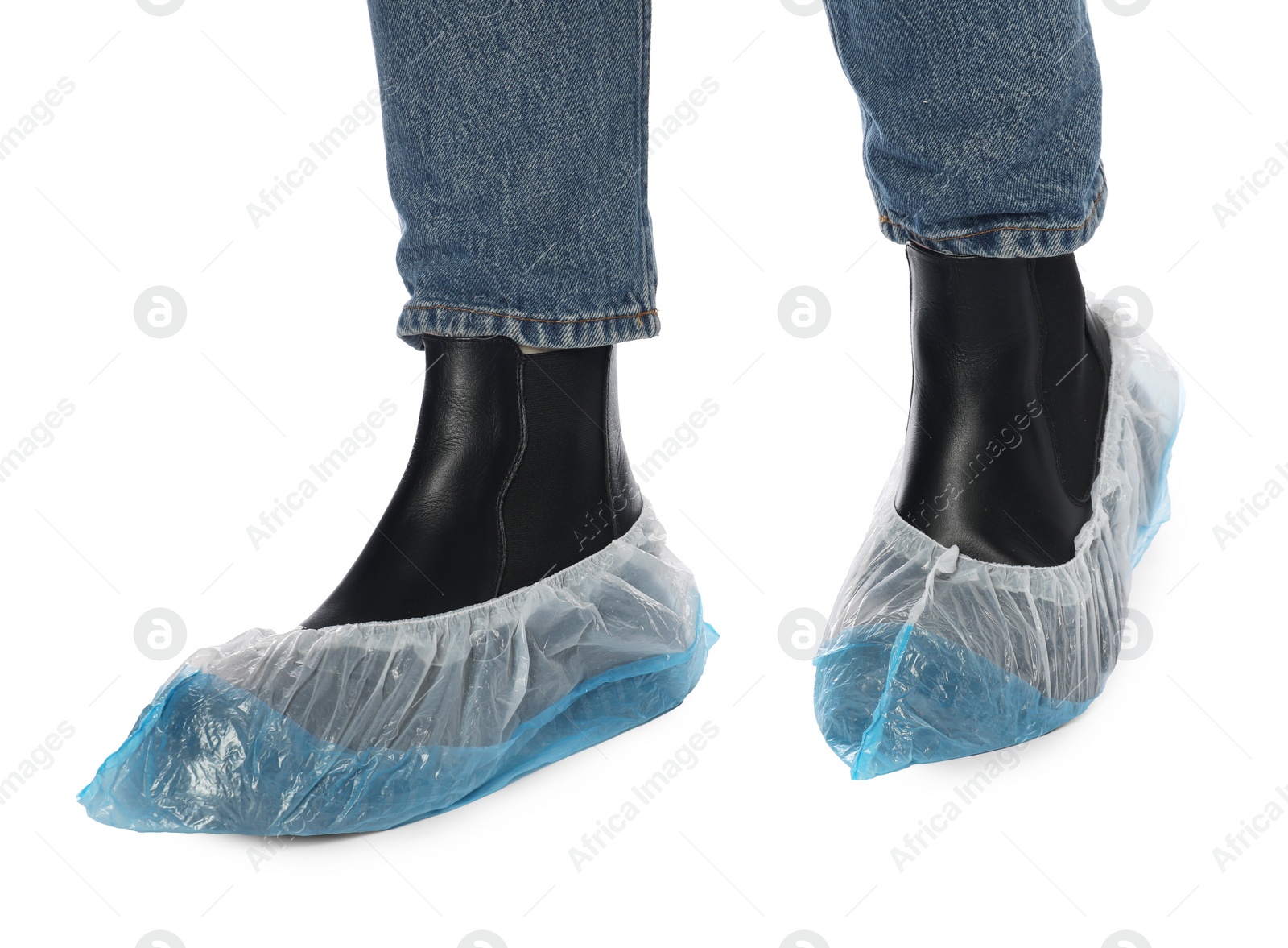 Photo of Woman wearing blue shoe covers onto her boots against white background, closeup