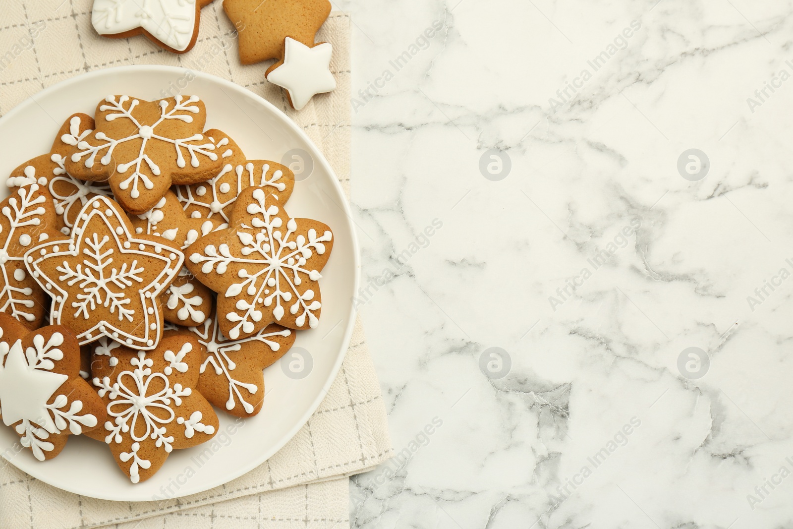 Photo of Tasty star shaped Christmas cookies with icing on white marble table, top view. Space for text