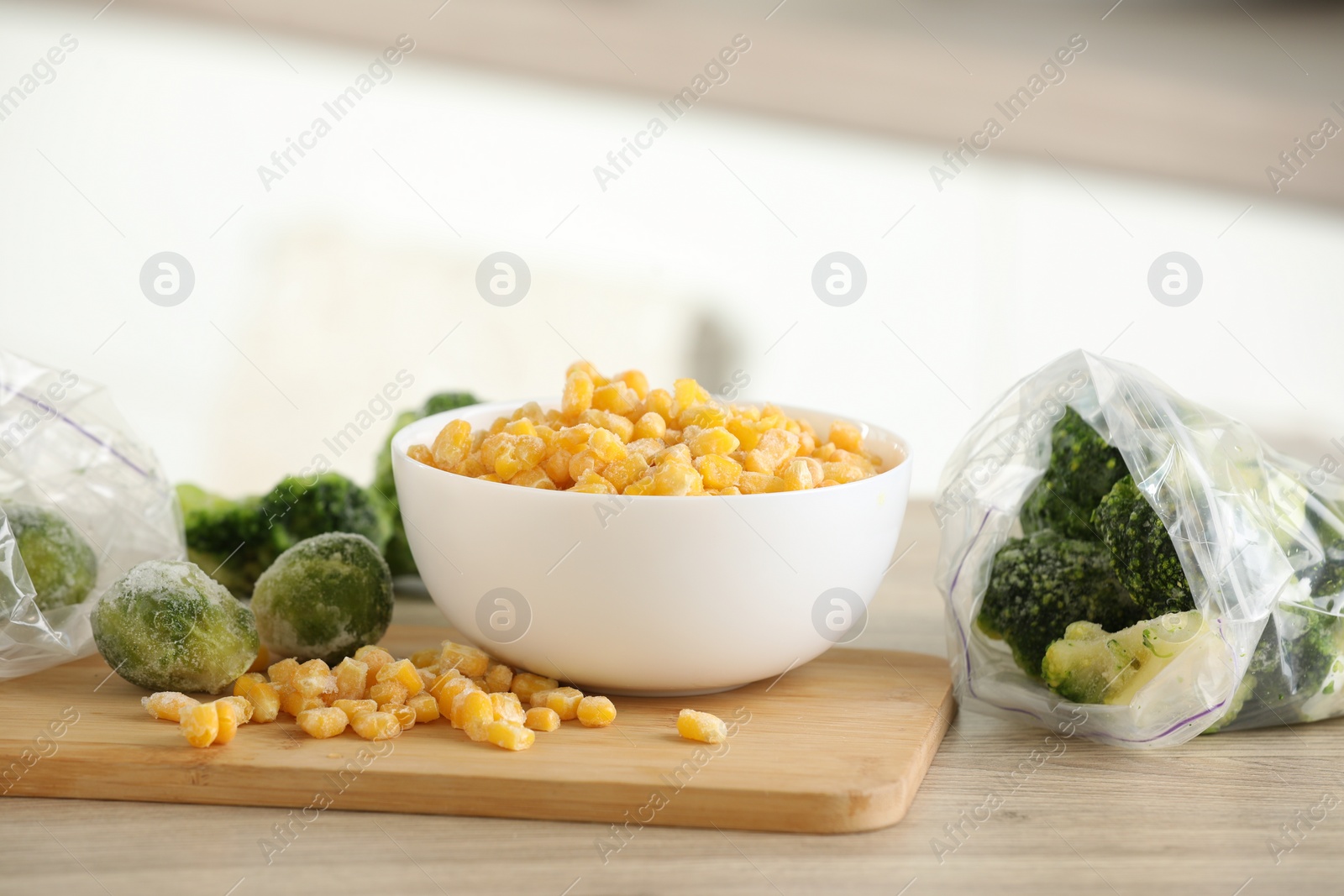 Photo of Frozen vegetables on wooden table indoors, closeup. Space for text