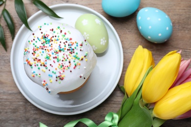 Photo of Flat lay composition with beautiful Easter cake and painted eggs on wooden table