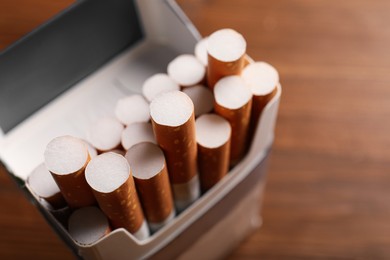 Pack of cigarettes on blurred background, closeup