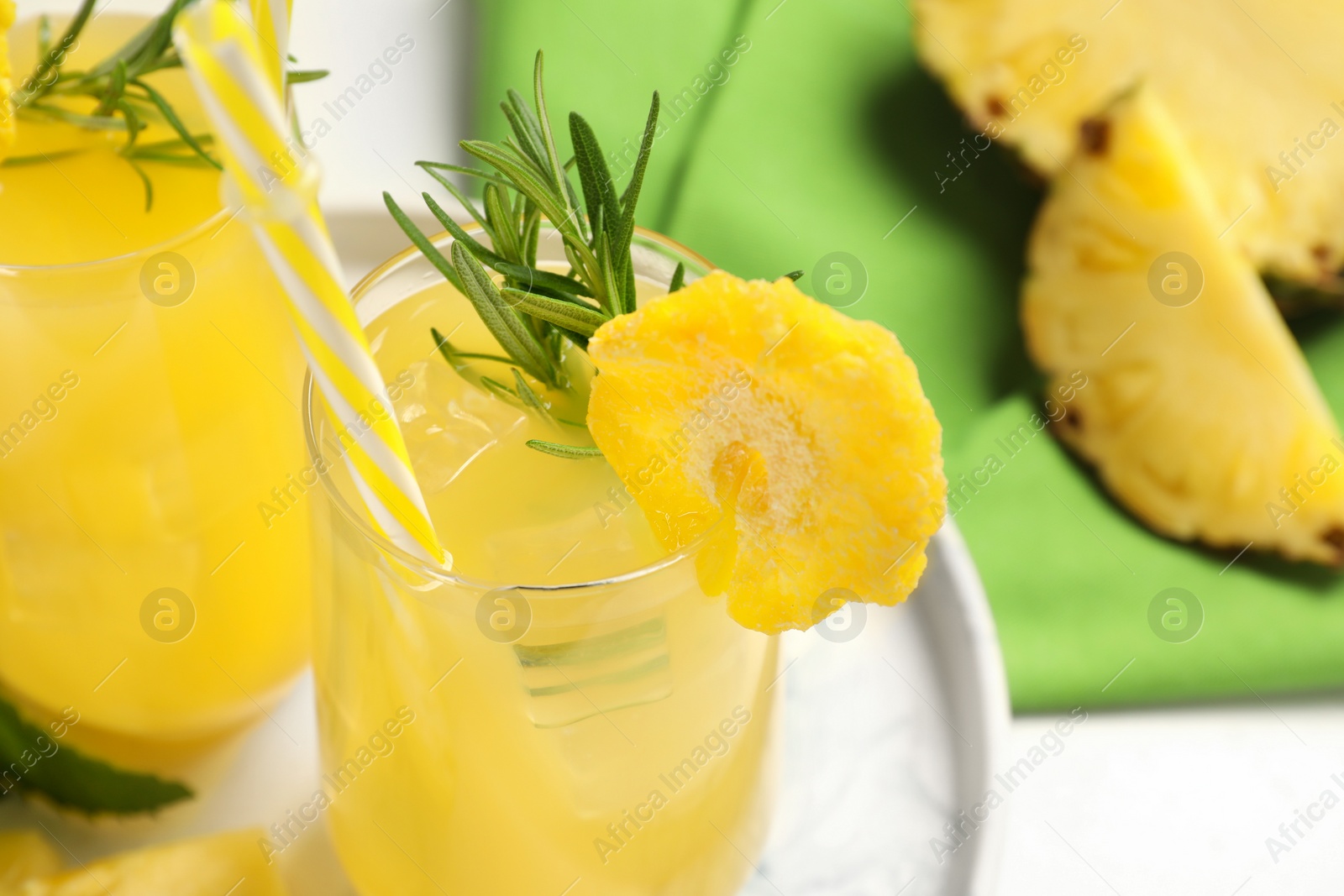 Photo of Glasses of tasty pineapple cocktail with rosemary on table, closeup