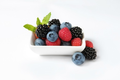 Photo of Bowl with raspberries and different berries on white background